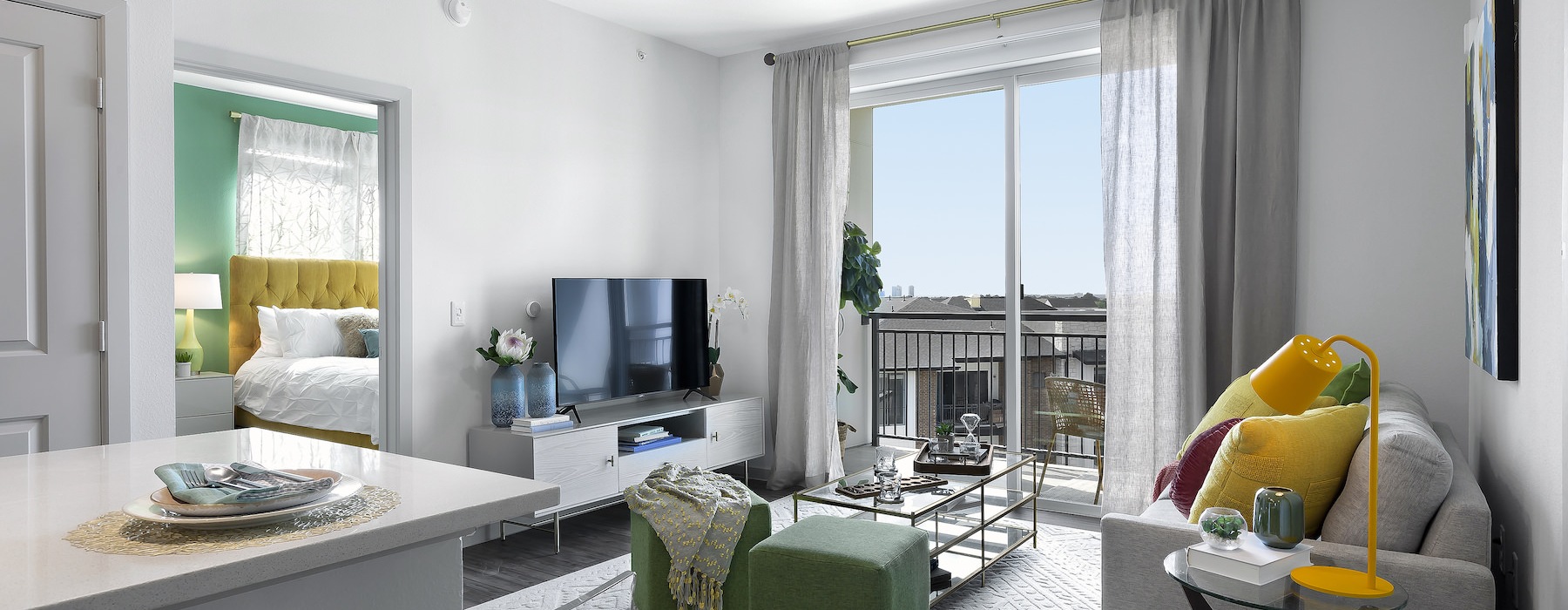 Spacious and well-lit living room with wood flooring and french doors at Korina at The Grove, a new apartment complex in Austin, TX